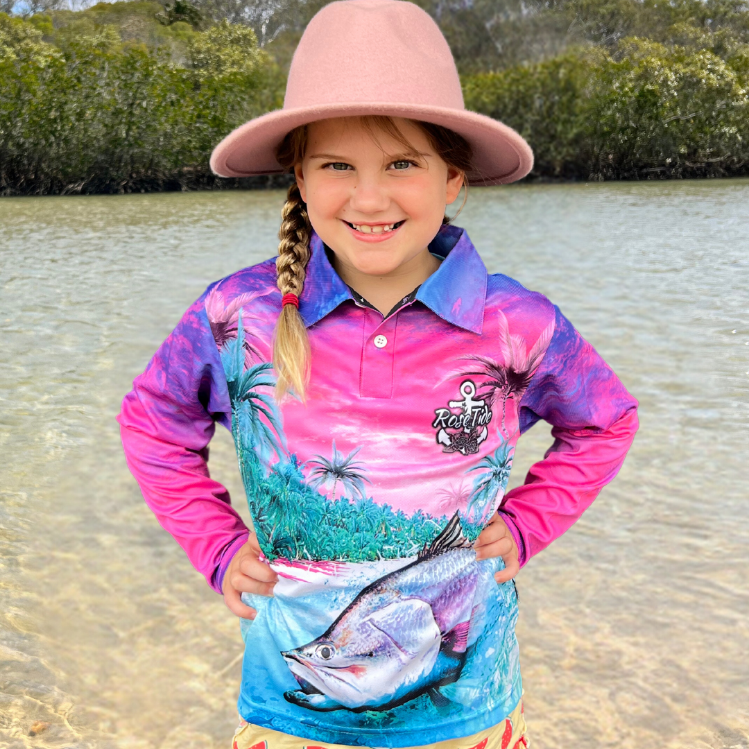 Girl wearing a bright pink and blue fishing shirt with a tropical scence and a barramundi 