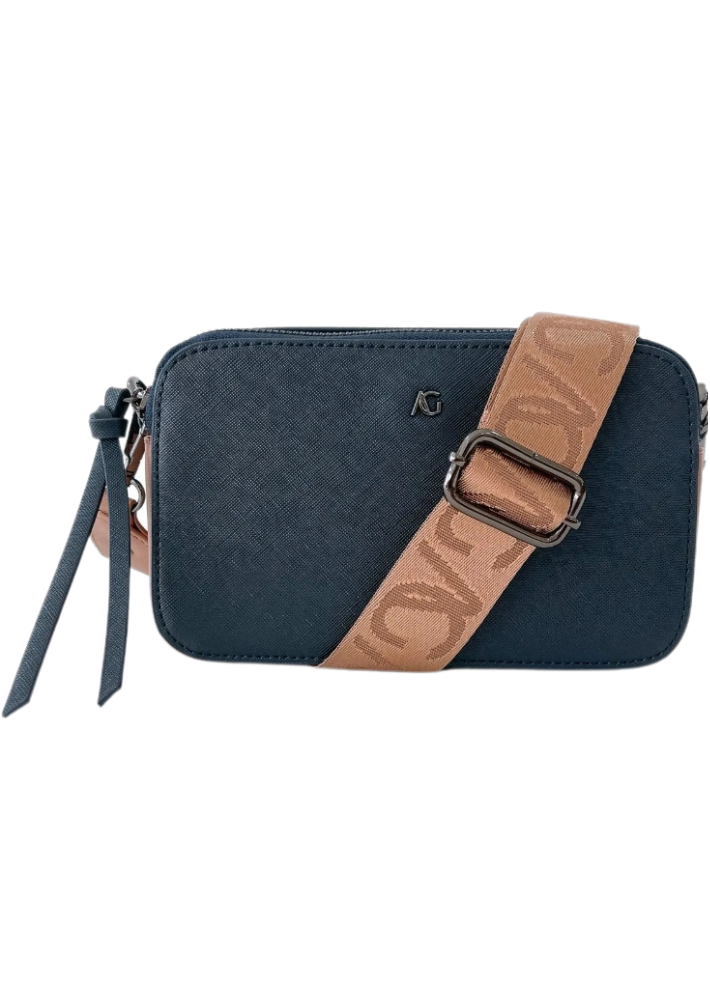 A dark blue vegan leather crossbody bag with silver zippers and a wide tan strap featuring a subtle embossed pattern. The bag has a small silver logo on the front and a minimalist design with a slim profile. The combination of navy blue and tan creates a sophisticated and versatile accessory.