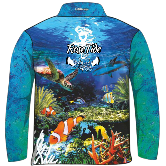 A long-sleeve women's and children's fishing shirt featuring a vibrant underwater scene with various sea creatures, including a lionfish, seahorse, clownfish, and stingray. The background transitions from deep blue water to a colourful coral reef at the bottom. The "Rose Tide" logo with an anchor and floral design is displayed on the chest.