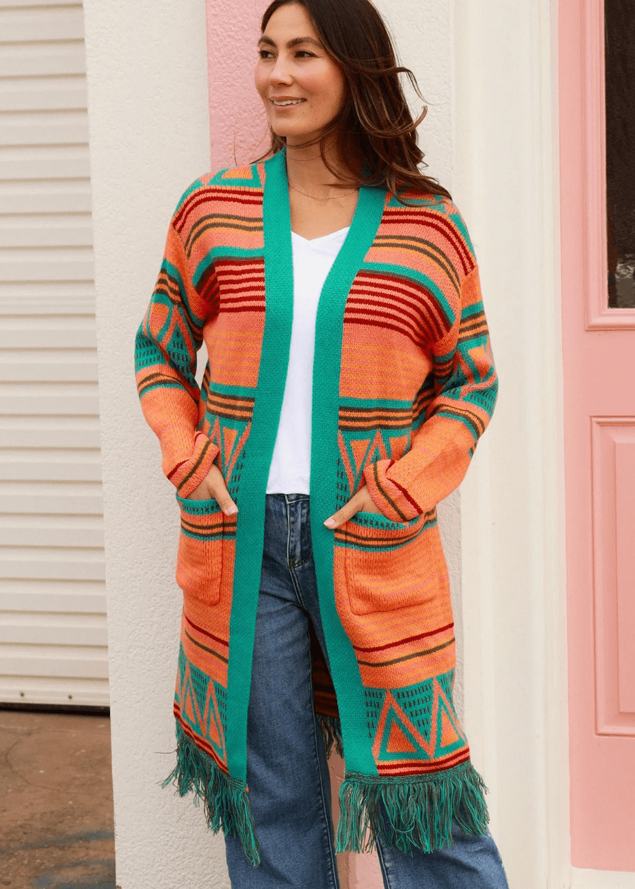 Women wearing a Geometric Knit Cardigan with orange, Turquoise, and Red Aztec Patterns and Fringe Hem