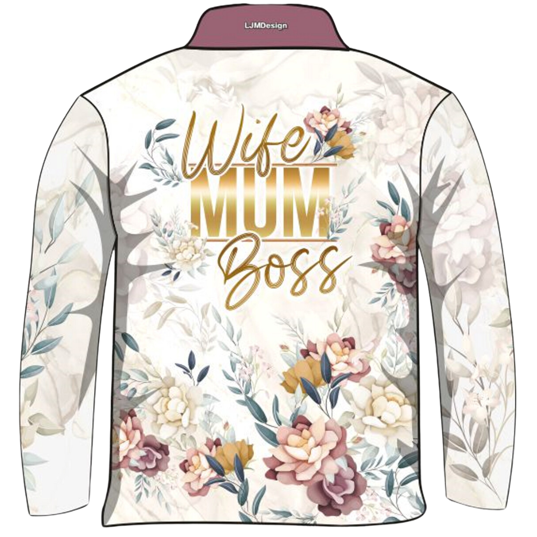 A cream-coloured long-sleeve Fishing Sun shirt adorned with floral patterns in soft pastel tones. The shirt features bold gold text in the centre that reads "Wife Mum Boss." The shirt has a buttoned collar and is labelled as "Wife Mum Boss - Floral."